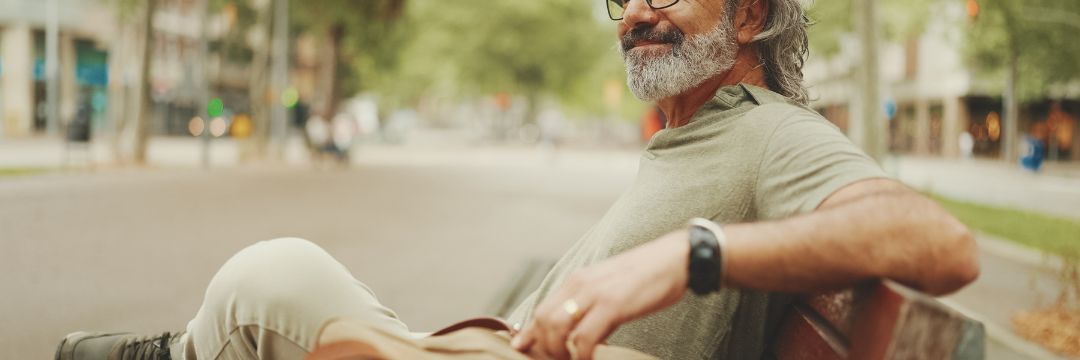 Man sitting and smiling on park bench